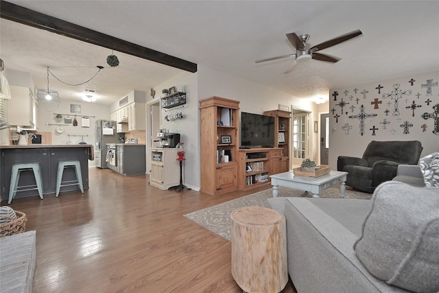 living room with dark wood-style flooring, beam ceiling, and a ceiling fan