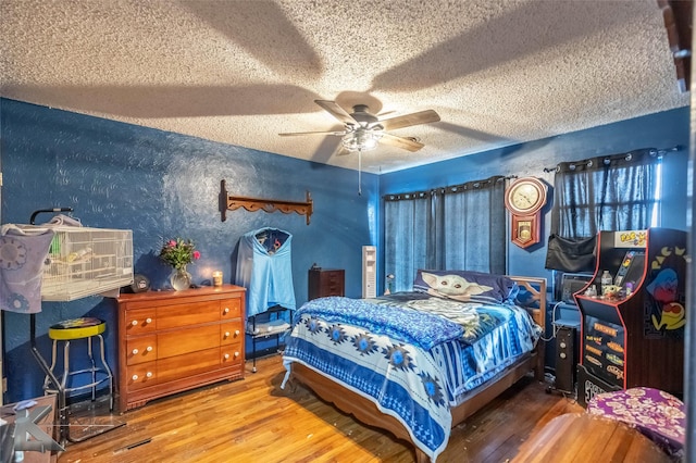 bedroom featuring a textured ceiling, wood finished floors, and a ceiling fan