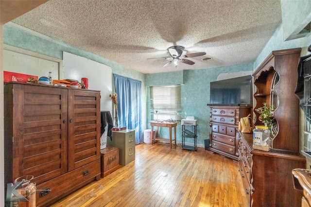 interior space with a textured ceiling, hardwood / wood-style flooring, and a ceiling fan