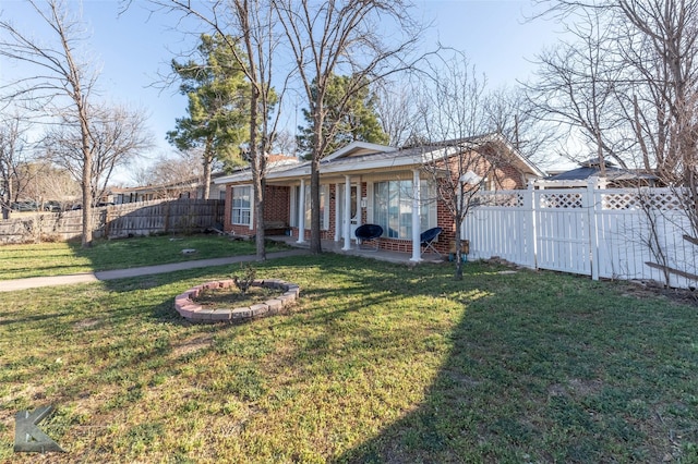 exterior space featuring fence private yard, a front yard, and brick siding