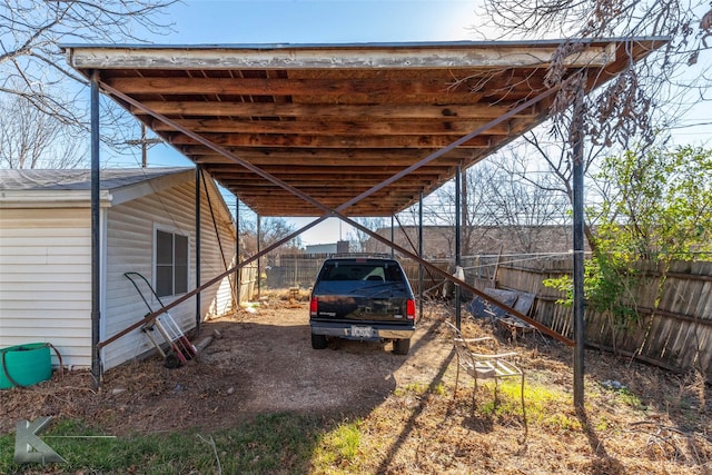 view of parking featuring a carport and fence