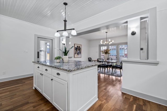 kitchen featuring dark wood-style flooring, pendant lighting, an inviting chandelier, ornamental molding, and white cabinets