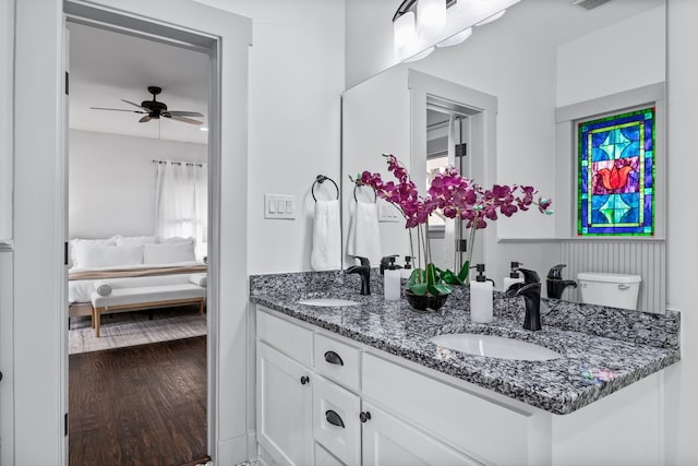 ensuite bathroom featuring wood finished floors, double vanity, a sink, and ensuite bathroom