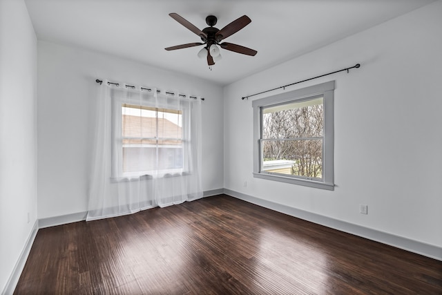 unfurnished room featuring ceiling fan, dark wood-type flooring, and baseboards