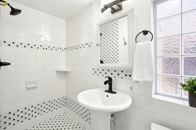 bathroom with tiled shower and tile walls