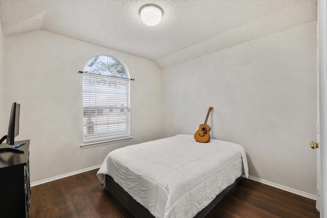 bedroom featuring vaulted ceiling, a textured ceiling, dark wood finished floors, and baseboards