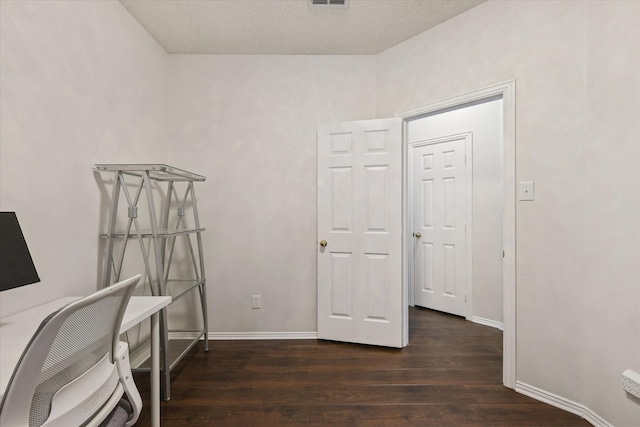 home office featuring visible vents, baseboards, and dark wood-type flooring