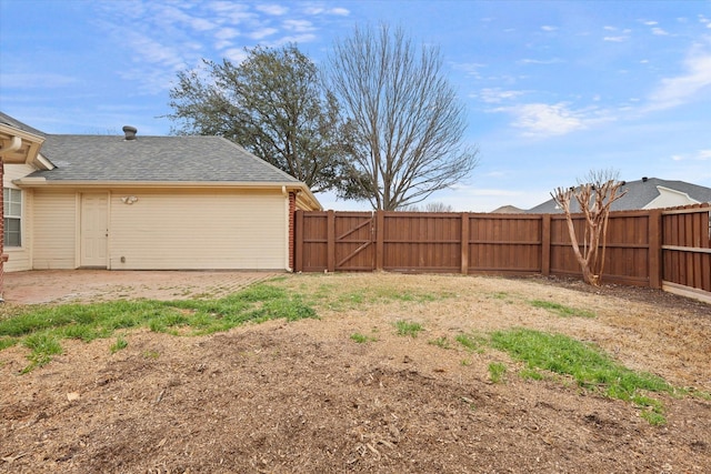 view of yard featuring a patio area, a fenced backyard, and a gate