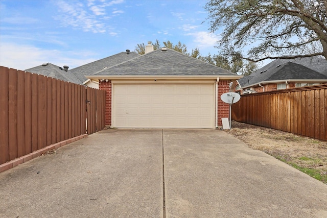 garage featuring driveway and fence