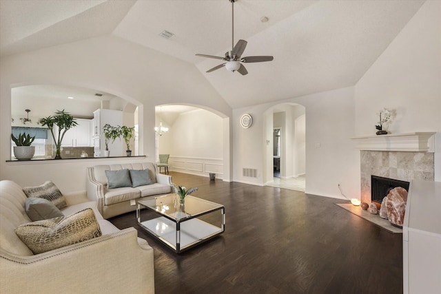 living room with ceiling fan, visible vents, a tiled fireplace, and wood finished floors