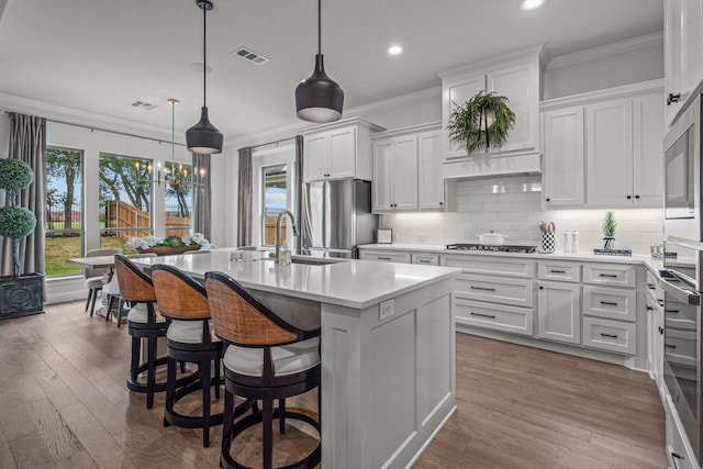 kitchen featuring ornamental molding, appliances with stainless steel finishes, visible vents, and tasteful backsplash