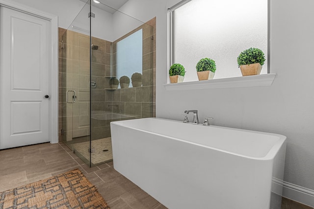 full bathroom featuring a stall shower and a freestanding tub