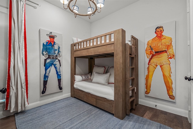 bedroom featuring baseboards, a chandelier, and wood finished floors