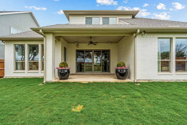 rear view of property with brick siding, a yard, roof with shingles, a ceiling fan, and a patio area