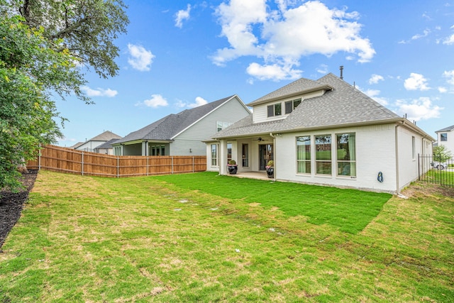 rear view of property with brick siding, a lawn, a patio area, ceiling fan, and a fenced backyard