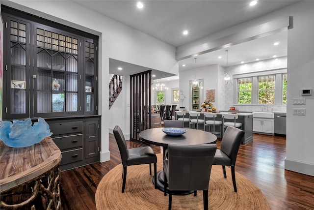 dining room with a notable chandelier, dark wood-type flooring, stairs, and recessed lighting