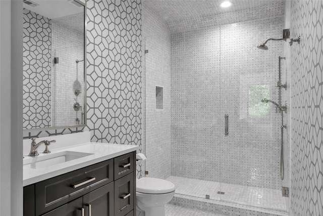 full bathroom with a stall shower, visible vents, vanity, and toilet