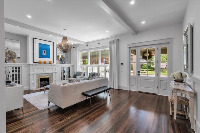 living area with a chandelier, recessed lighting, dark wood-type flooring, a fireplace, and beamed ceiling