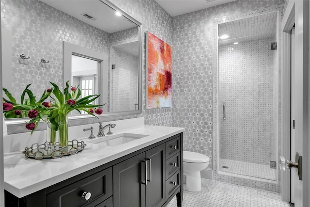 full bath featuring wallpapered walls, a stall shower, visible vents, toilet, and vanity