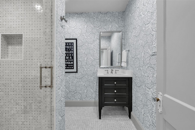 bathroom featuring tile patterned flooring, vanity, baseboards, and wallpapered walls