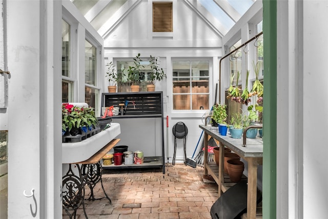 sunroom / solarium featuring lofted ceiling with skylight