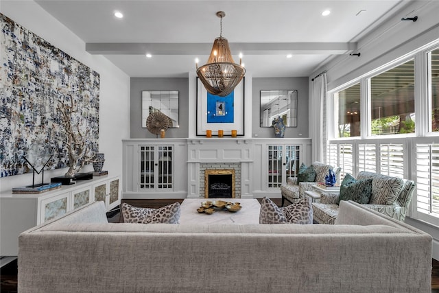 living area with a chandelier, a stone fireplace, recessed lighting, wood finished floors, and beamed ceiling