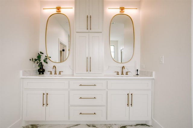 bathroom featuring double vanity, marble finish floor, and a sink