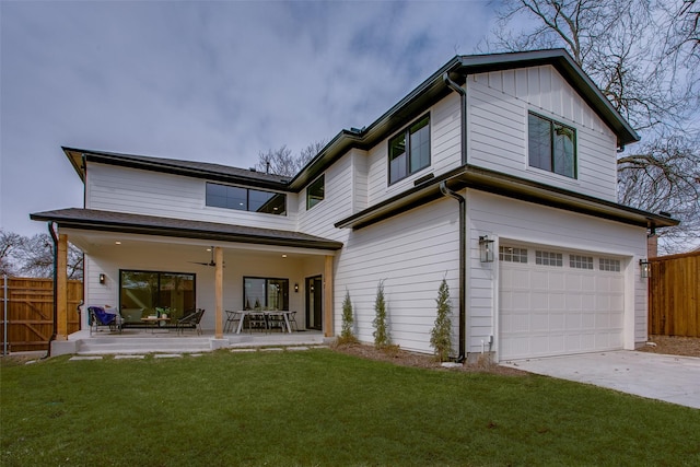 rear view of house featuring a patio, a garage, fence, a lawn, and board and batten siding