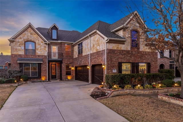 view of front of property featuring a balcony, driveway, an attached garage, stone siding, and brick siding