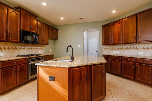 kitchen featuring gas cooktop, visible vents, arched walkways, oven, and black microwave