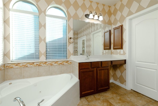 bathroom with tile patterned floors, vanity, a whirlpool tub, and wallpapered walls