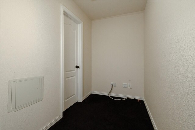 spare room featuring baseboards and dark colored carpet