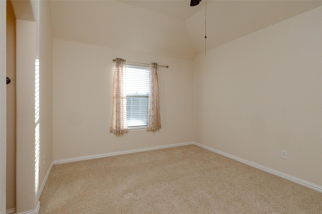 carpeted spare room featuring vaulted ceiling, baseboards, and ceiling fan