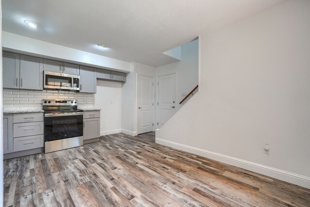 unfurnished living room with recessed lighting, a fireplace, baseboards, and wood finished floors