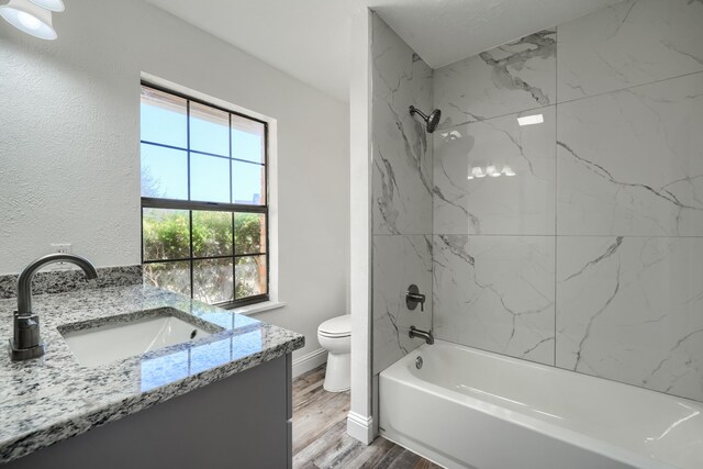 full bath featuring baseboards, wood finished floors,  shower combination, vanity, and a closet