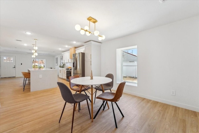 dining space featuring light wood-style floors, recessed lighting, baseboards, and an inviting chandelier