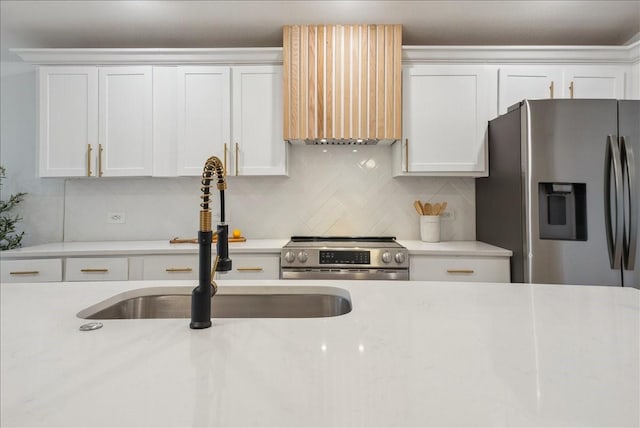 kitchen with stainless steel appliances, a sink, and white cabinets