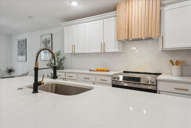 kitchen featuring tasteful backsplash, light stone countertops, stainless steel range with electric stovetop, white cabinetry, and a sink