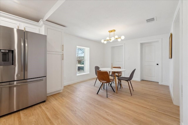 dining room featuring light wood-style floors, visible vents, baseboards, and an inviting chandelier