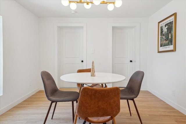 dining space with light wood-style flooring and baseboards