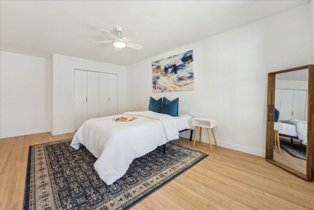 bedroom featuring light wood-style floors, a ceiling fan, baseboards, and a closet