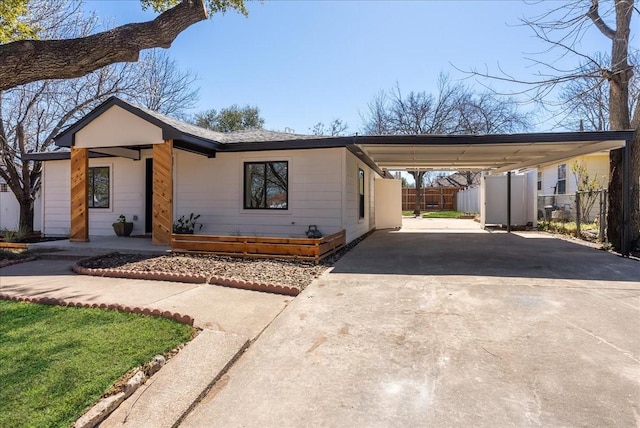 view of front facade with driveway, fence, and a carport