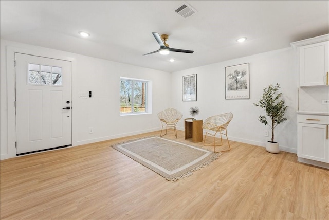 living area with light wood-style floors, recessed lighting, visible vents, and baseboards