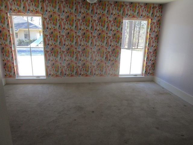 carpeted spare room with baseboards