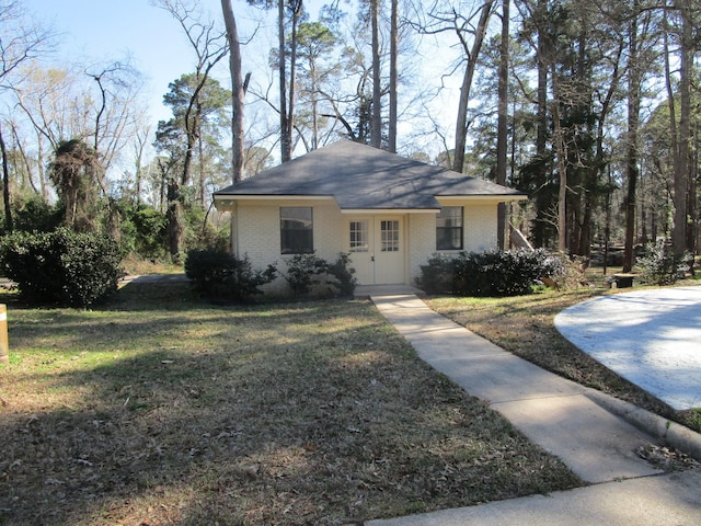 view of front of house featuring brick siding and a front lawn