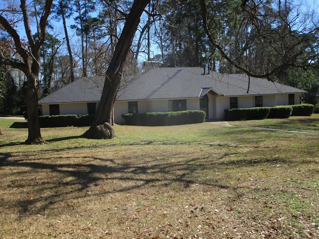 ranch-style house with stucco siding and a front yard