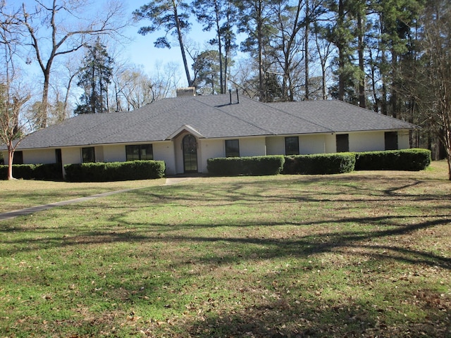 single story home featuring roof with shingles, a chimney, and a front yard