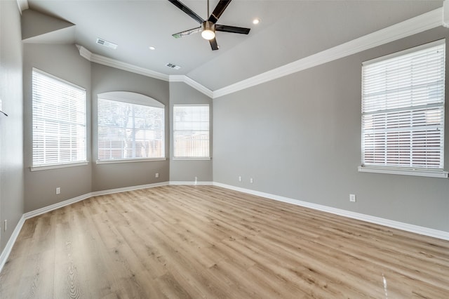 empty room featuring lofted ceiling, visible vents, baseboards, a ceiling fan, and ornamental molding