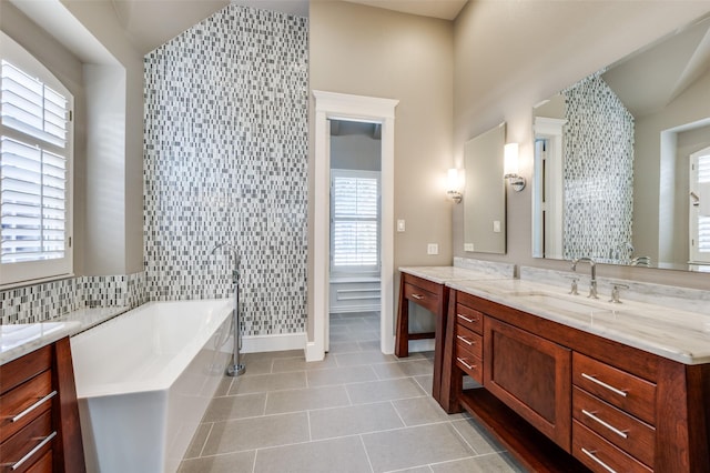 full bathroom featuring lofted ceiling, a garden tub, vanity, and tile patterned floors