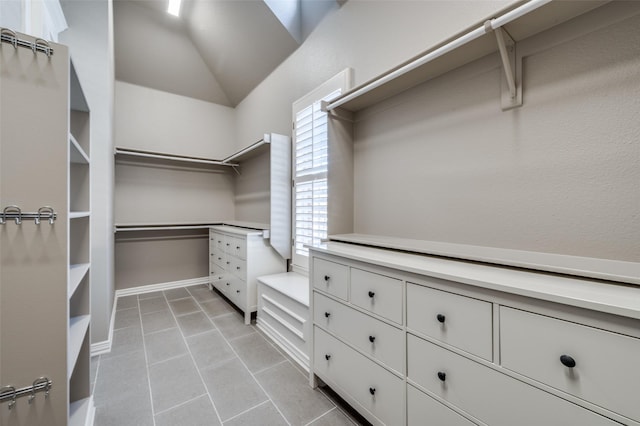 spacious closet featuring lofted ceiling and light tile patterned flooring